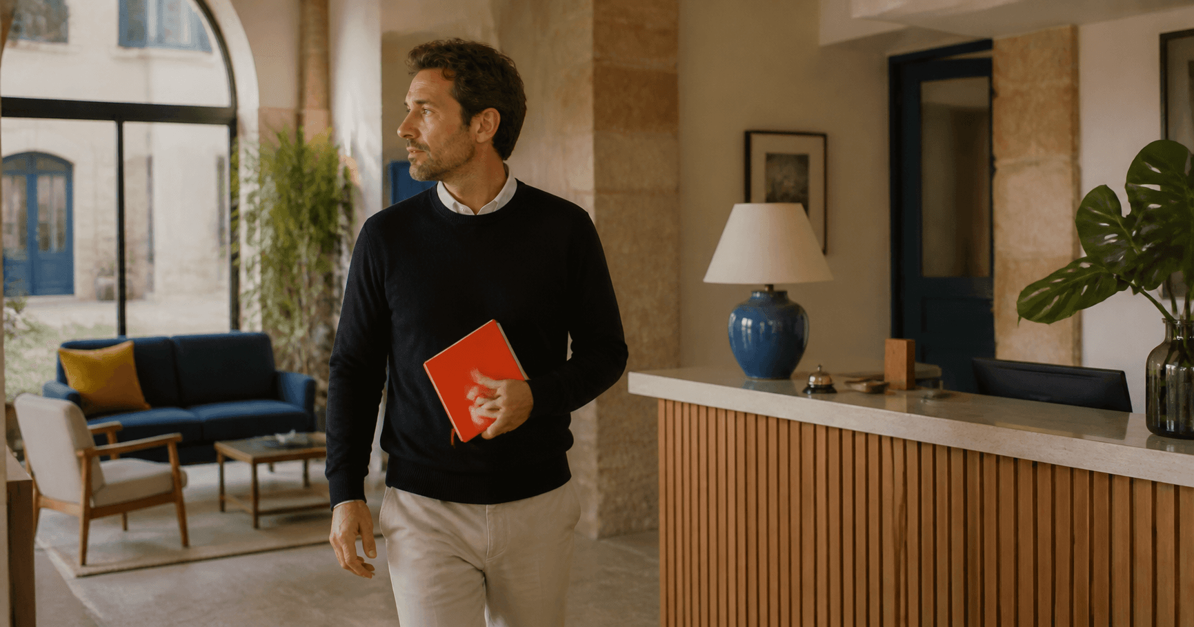 Gerente de un pequeño hotel observando el negocio con un cuaderno rojo
