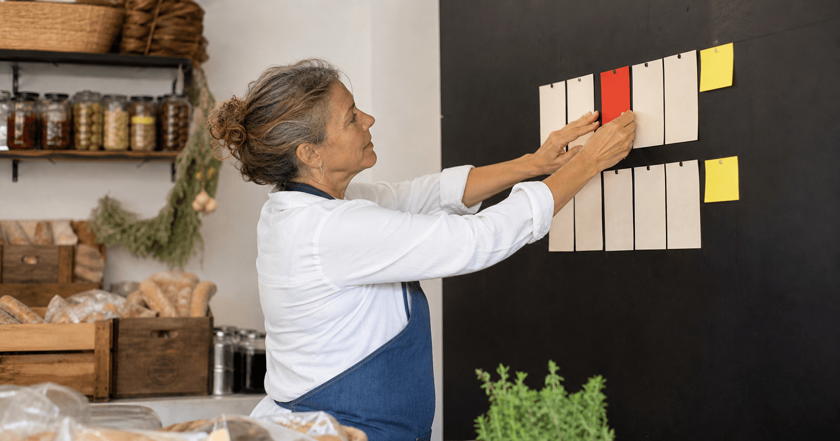 Empresaria ordenando las etapas de su plan de marketing en una pared